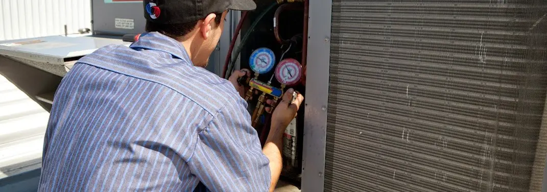 HVAC technician servicing a condenser unit in Jefferson City