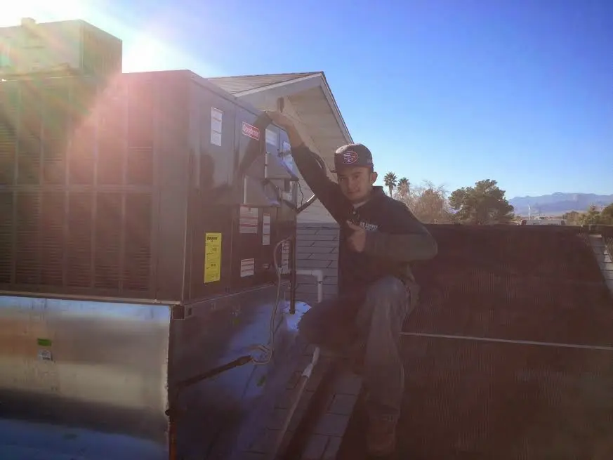 HVAC technician performing Air Duct Cleaning on a rooftop unit in Jefferson City
